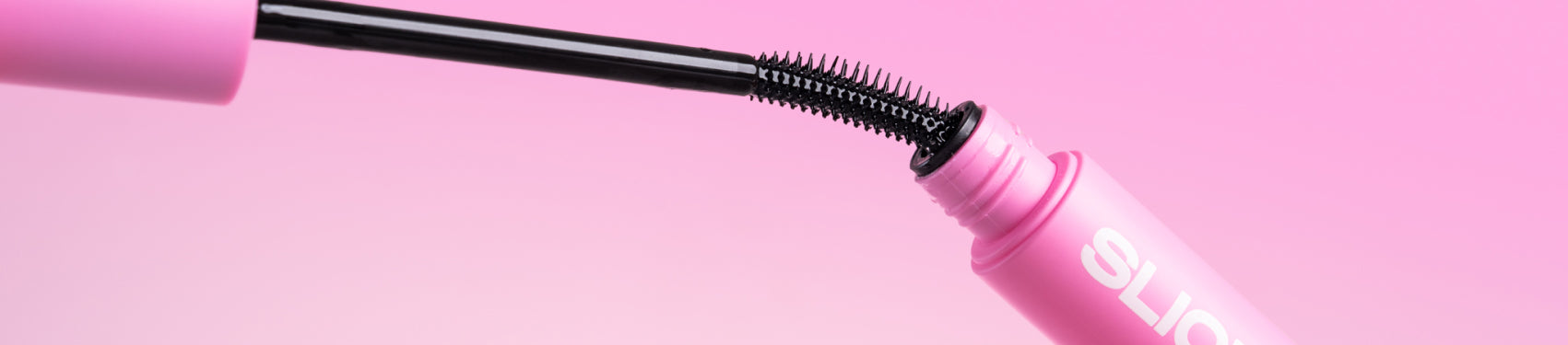 Pink slick stick with black wand on a pink background.