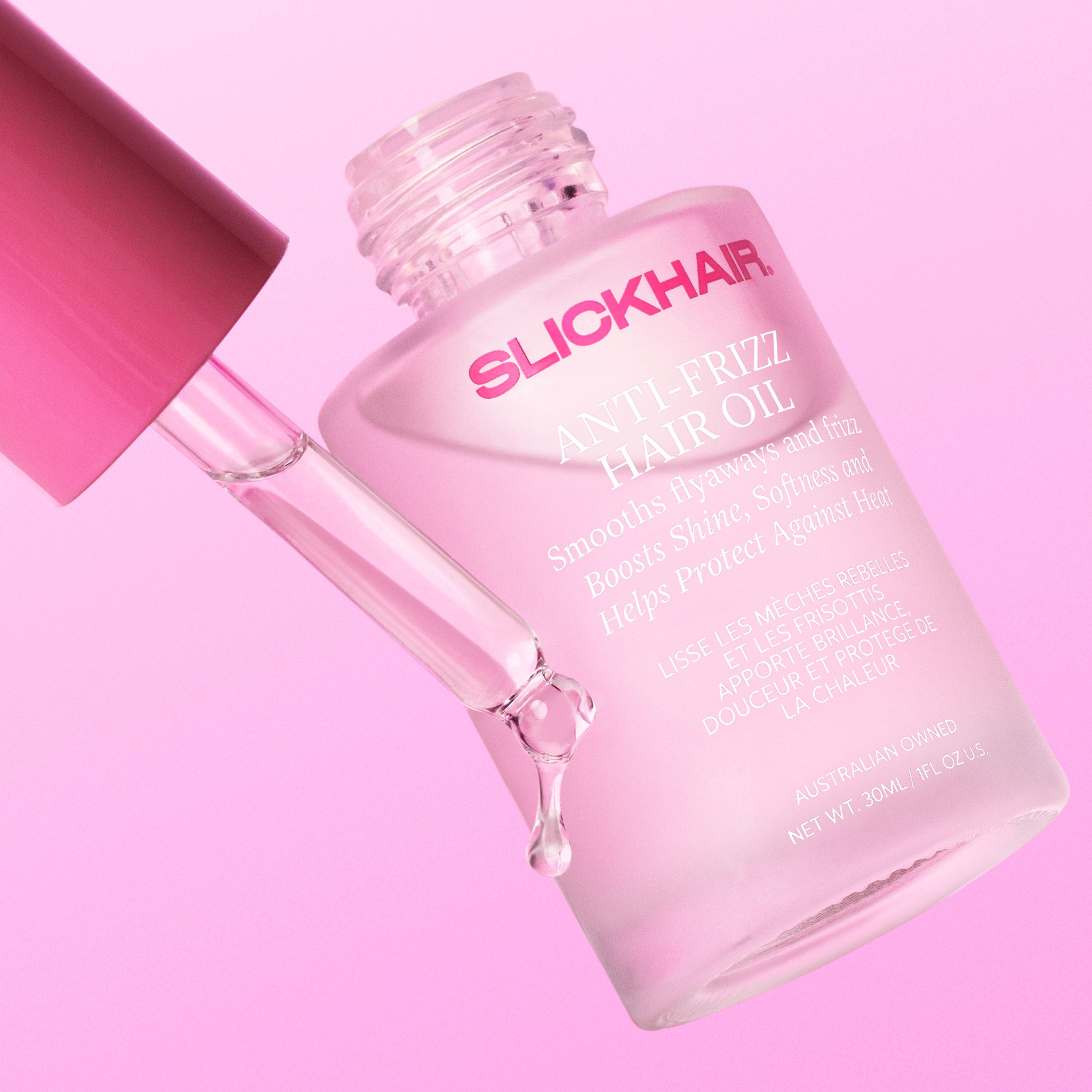 Close up image of a bottle of SLICKHAIR anti-frizz hair oil on a pink background.