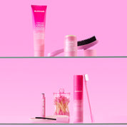 Collection of SLICKHAIR pink hair care products on a pink background.