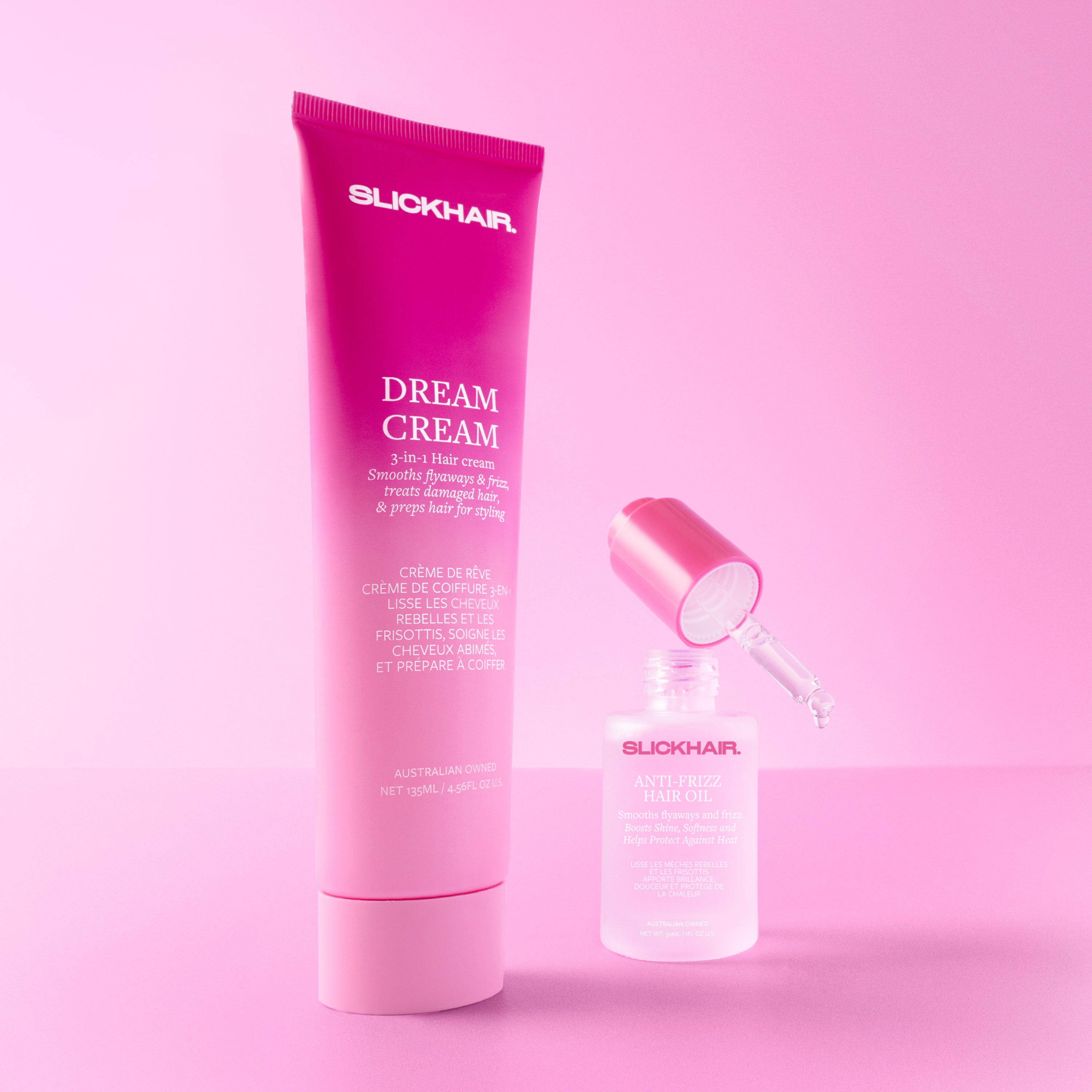 SLICKHAIR Dream Cream tube and anti-frizz hair oil bottle on a pink background.
