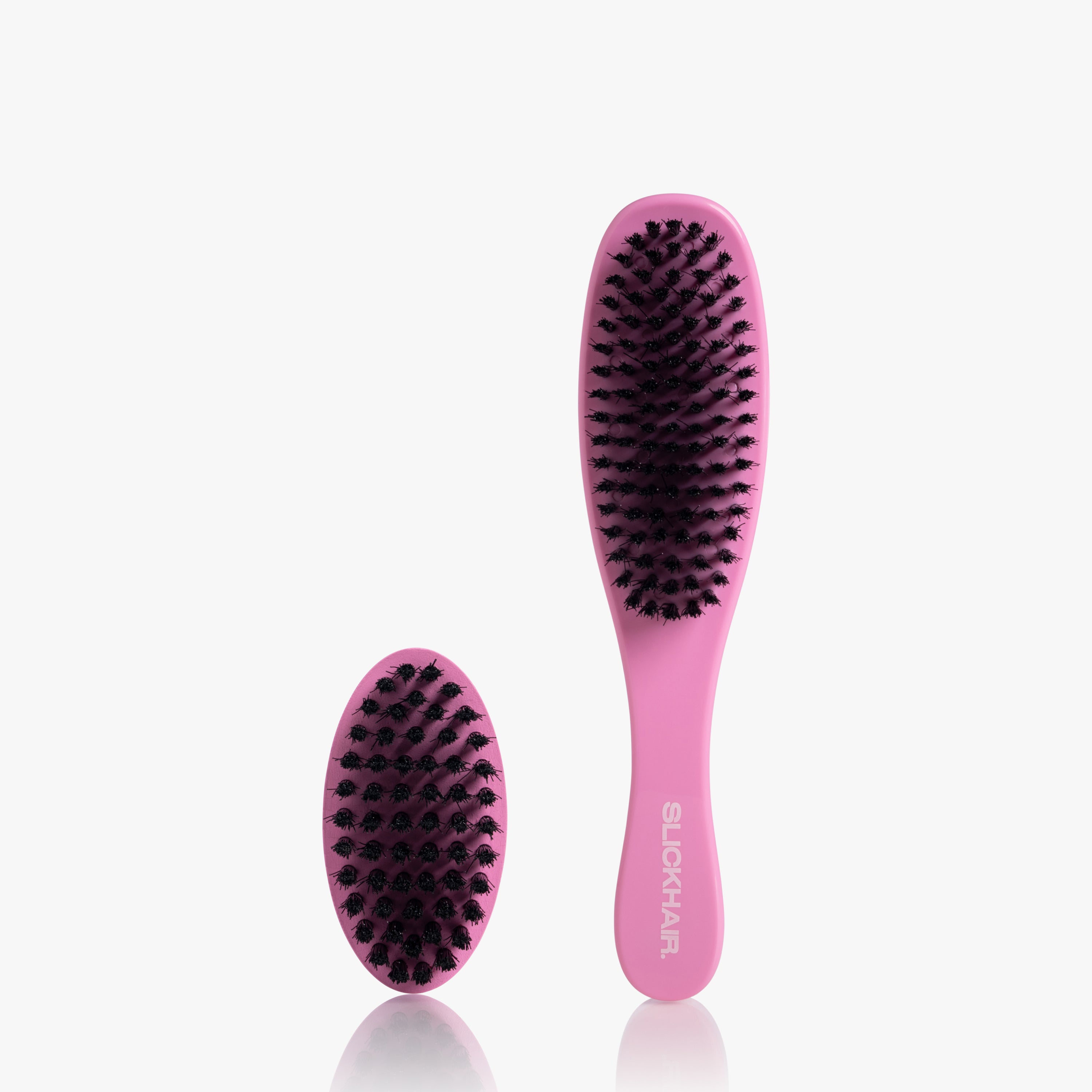 Two pink hairbrushes with black bristles on a white background