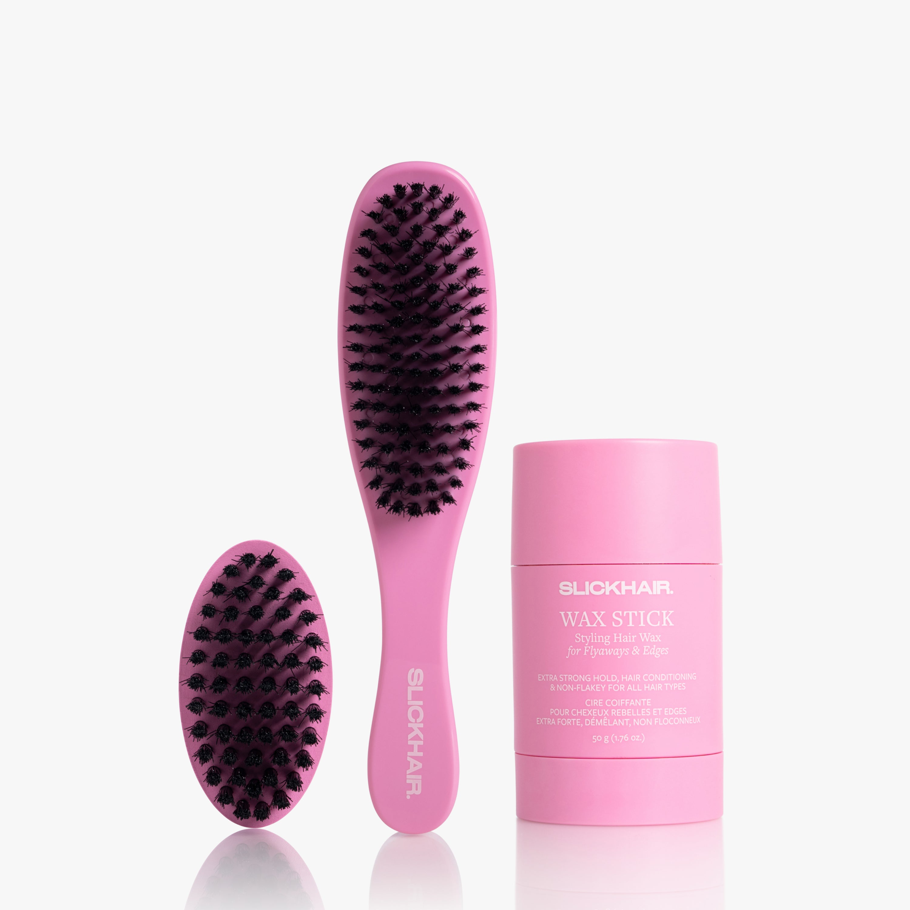 Pink smoothing hairbrush, pink travel hairbrush and wax stick on a white background